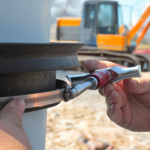 Hand putting a metal clamp on a rubber connector